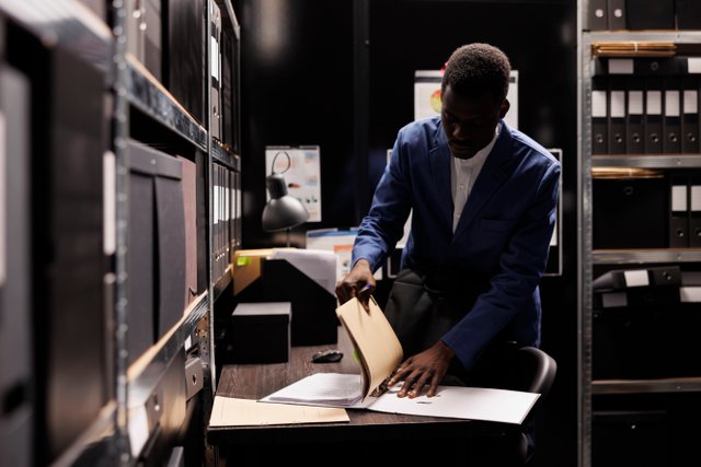 african-american-manager-gathering-his-stuff-preparing-leave-job-late-night-after-working-accountancy-report-file-room-employee-searching-bureaucracy-record-corporate-depository.jpg