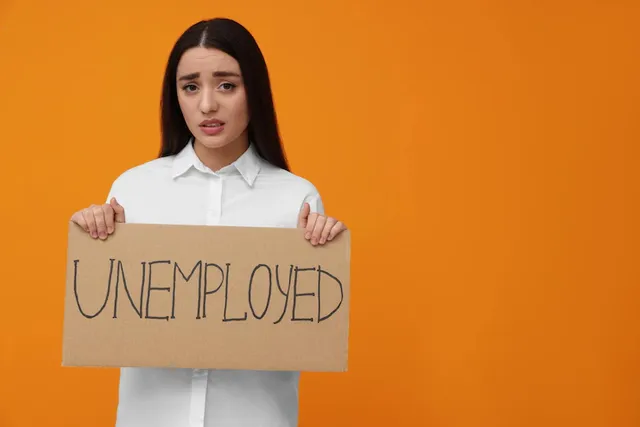 young-woman-holding-sign-with-word-unemployed-orange-background-space-text_495423-52401.webp