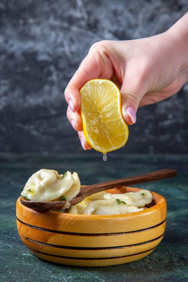 front-view-meat-dumplings-with-lemon-juice-squeezing-by-female-dark-blue-surface_179666-34507.jpg