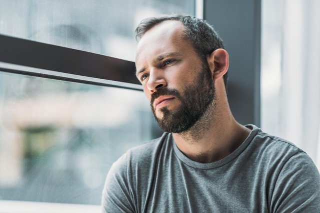 stock-photo-frustrated-bearded-man-leaning-window.jfif