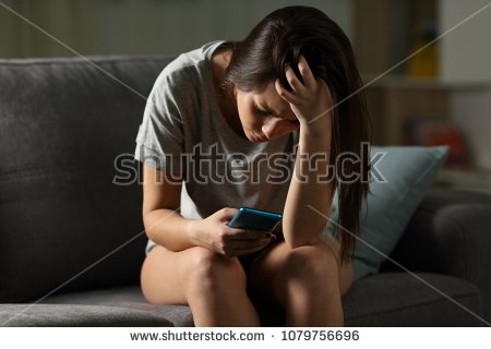 stock-photo-sad-teen-being-victim-of-cyber-bullying-online-sitting-on-a-couch-in-the-living-room-at-home-1079756696.jpg