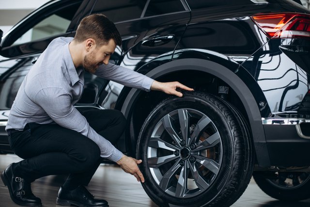 man-choosing-car-checking-tires.jpg