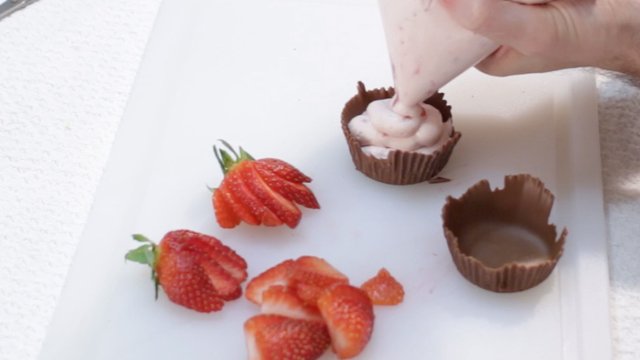 piping strawberry mousse into chocolate cups.jpg