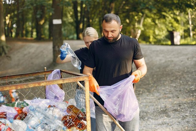 couple-collects-garbage-garbage-bags-park_1157-27405.jpg