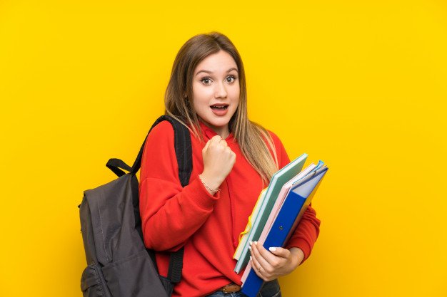 teenager-student-girl-yellow-wall-celebrating-victory_1368-49451.jpg