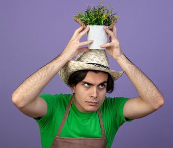 jardinero-macho-joven-confundido-uniforme-vistiendo-sombrero-jardineria-sosteniendo-flor-maceta-cabeza_141793-89109.jpg