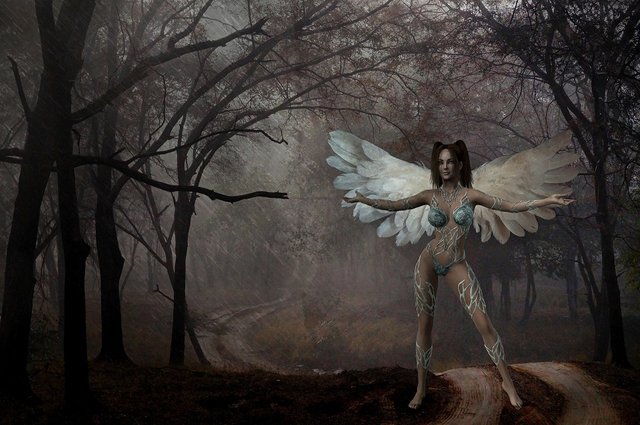 ángel femenino rodeada de niebla en un bosque