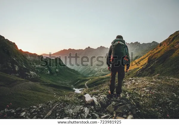 man-hiking-sunset-mountains-heavy-600w-723981925.webp