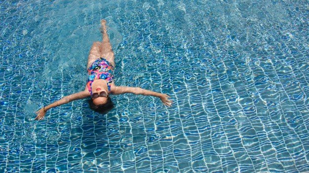 rear-view-of-a-woman-swimming-at-relaxing-pool-with-wide-open-arms-on-crystal-clear-water_1253-1034.jpg