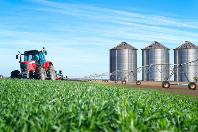 agriculture-food-production-concept-with-tractor-machine-silos-irrigation-system.jpg