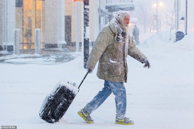 9179662-6650115-A_man_moves_his_luggage_through_the_snow_covered_streets_in_Buff-a-4_1548888764610.jpg