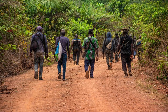 free-photo-of-people-carrying-rifle-while-walking-on-the-dirt-road.jpeg