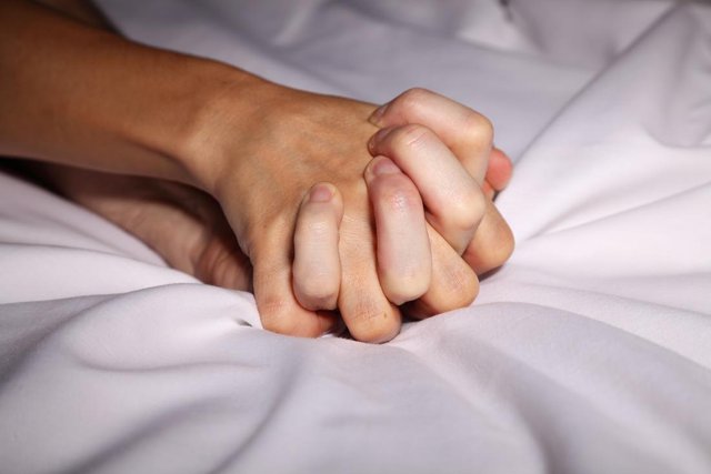 couple-holding-hands-in-bed-during-sex.jpg