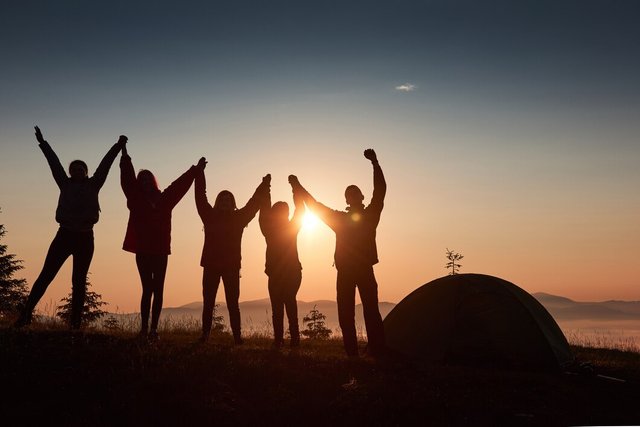 silhouette-group-people-have-fun-top-mountain-near-tent-sunset_146671-18472.jpg