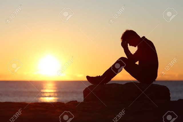 37771739-sad-man-silhouette-worried-on-the-beach-at-sunset-with-the-sun-in-the-background.jpg