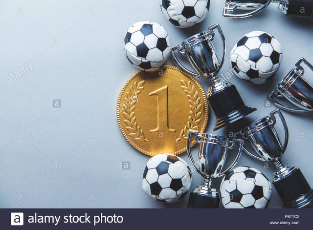 gold-first-place-winners-medal-and-trophy-with-a-soccer-ball-football-success-achievement-concept-P87TC2.jpg