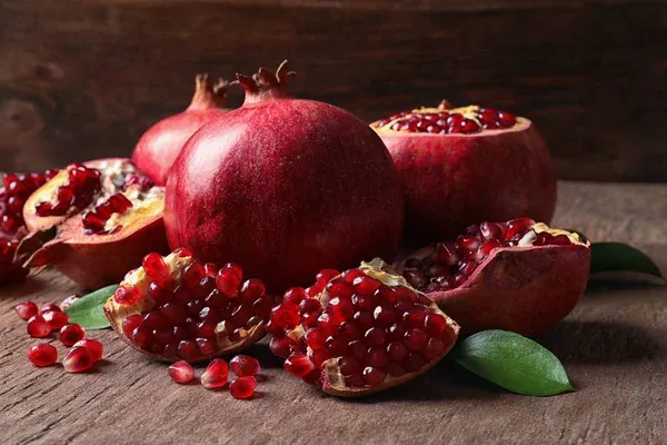 depositphotos_246705870-stock-photo-composition-ripe-pomegranates-leaves-table.jpg