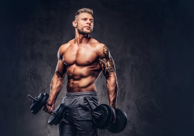 powerful-stylish-bodybuilder-with-tattoo-his-arm-doing-exercises-with-dumbbells-isolated-dark-background.jpg