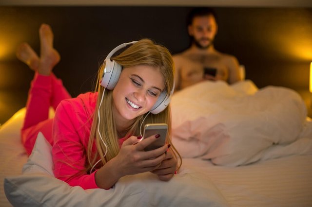 young-happy-women-white-bed-using-mobile-phone-with-headphones-boyfriend-background-concept-about-technology-people_639032-80.jpg