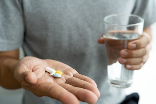 vecteezy_close-up-of-a-man-holding-a-dietary-supplement-or-medication_17155267.jpg