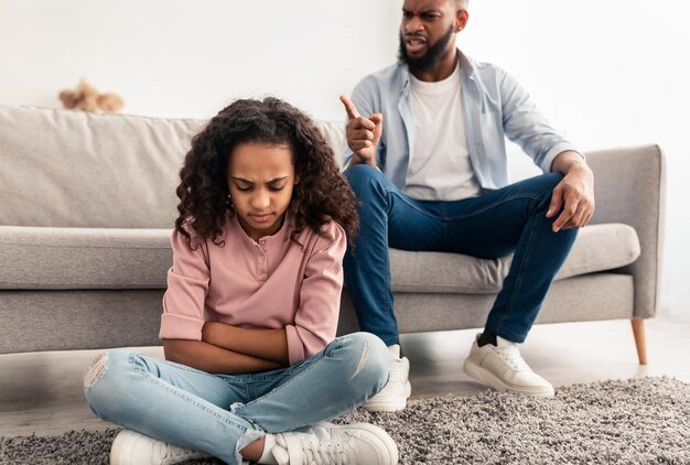 naughty-kid-portrait-angry-annoyed-african-american-father-scolding-his-upset-little-daughter-her-behaviour-while-she-sitting-floor-home-family-conflicts-punishment-concept_568137-668.jpg