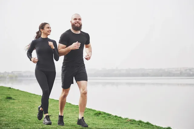 couple-jogging-running-outdoors-park-near-water-young-bearded-man-woman-exercising-together-morning_146671-14833.webp