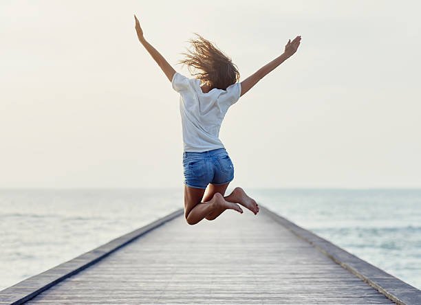 back-view-of-jumping-girl-on-the-pier-picture-id605763388.jpeg