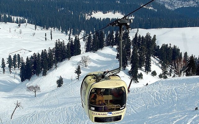 Travelers-riding-a-cable-car-over-a-valley-covered-in-snow-in-Gulmarg-ss30102017.jpg