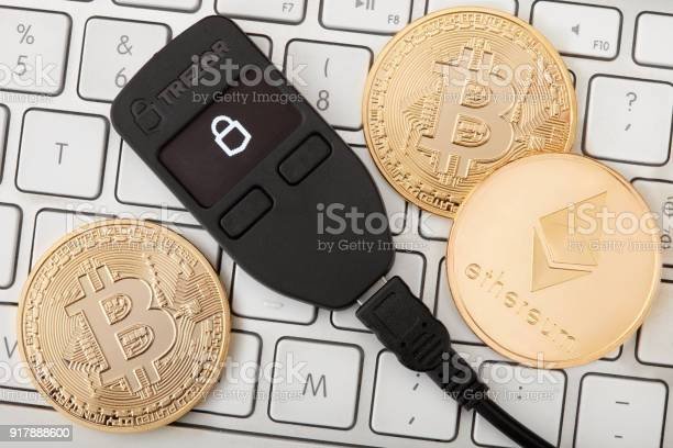 trezor-hardware-wallet-for-cryptocurrency-on-keyboard-with-golden-picture-id917888600.jpg