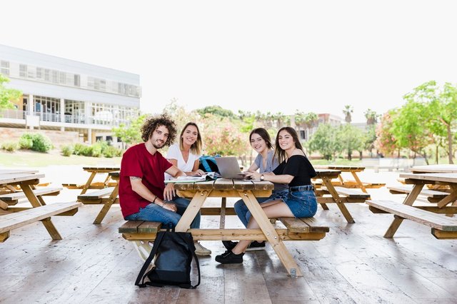 smiling-students-studying-together-table_23-2147850724.jpg