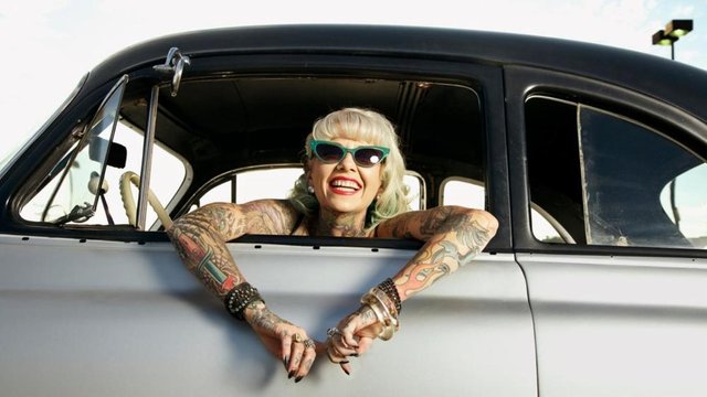 woman+with+tattoo+in+a+vintage+car.jfif