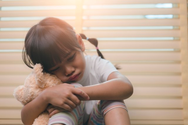 vecteezy_close-up-lonely-little-girl-hugging-toy-sitting-at-home_8427709_168.jpg