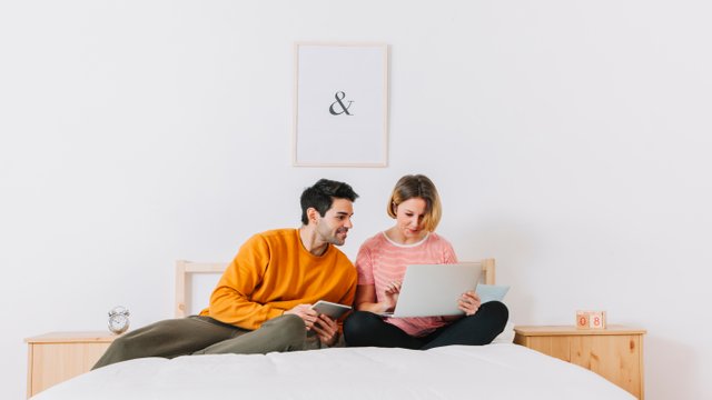 cheerful-couple-browsing-laptop-bed.jpg