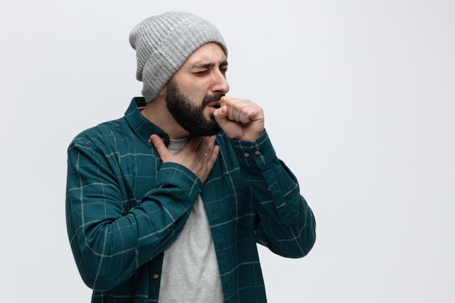 unhealthy-young-man-wearing-winter-hat-keeping-hand-chest-fist-front-mouth-coughing-with-closed-eyes-isolated-white-background-with-copy-space.jpg