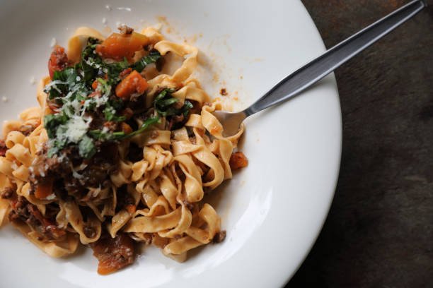 pasta-fettuccine-bolognese-with-beef-and-tomato-sauce-on-wood-background-in-dark-tone-mystic.jpg