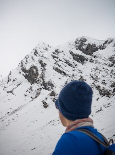 free-photo-of-a-person-in-a-blue-hat-looking-at-a-snowy-mountain.jpeg