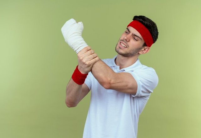 young-sporty-man-headband-touching-his-bandaged-hand-feeling-pain-standing-green-background_141793-67749.jpg