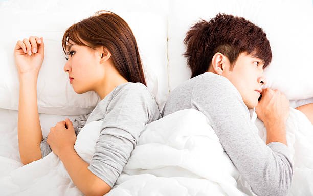 upset-young-couple-lying-side-by-side-in-bed-picture-id497064234.jpg