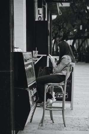 free-photo-of-brunette-woman-sitting-on-bar-stool-on-sidewalk.jpeg