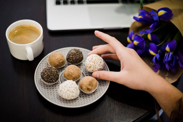 close-up-hand-holding-gourmet-assorted-truffles-from-plate-black-desk_23-2148028519.jpg