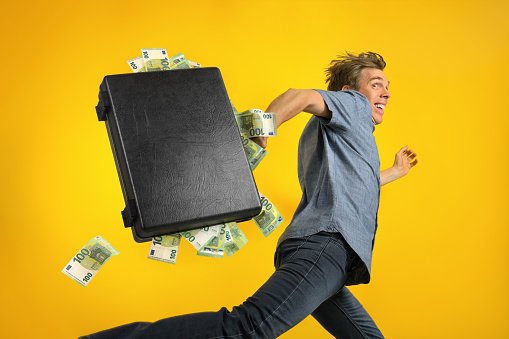 man-running-away-with-a-briefcase-overstuffed-with-cash.jpg