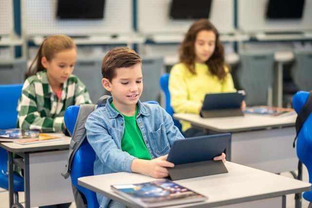 boy-girls-sitting-desk-looking-tablet_259150-60206.jpg