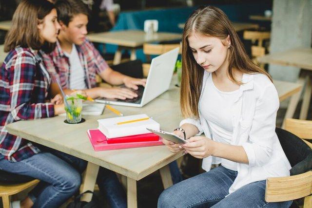 girl-with-classmates-table-using-tablet_23-2147655818.jpg