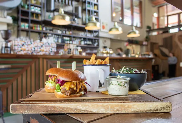 hamburgers-with-fries-cup-sauce-wooden-tray_181624-2600.webp