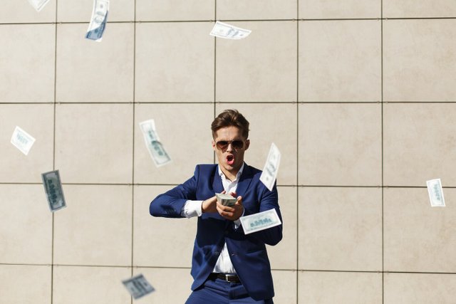 young-businessman-throughs-around-dollars-dances-street_8353-7195.jpg