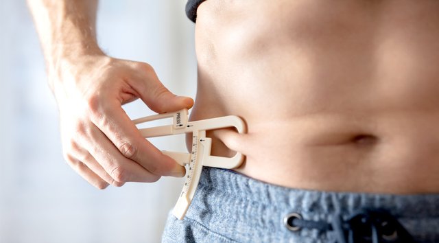 Man-Measuring-His-Body-Fat-With-Calipers.jpg