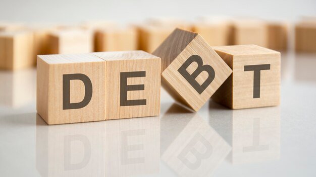 wooden-cubes-with-letters-debt-bright-surface-gray-table-business-concept_384017-3349.jpg