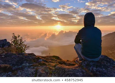 man-sitting-on-mountain-watching-260nw-458752945.webp