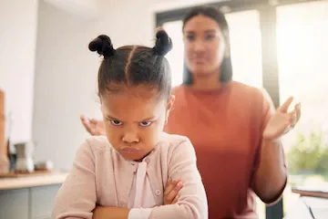 angry-little-girl-unhappy-upset-after-fight-being-scolded-by-mother-frowning-with-attitude-arms-crossed-naughty-child-looking-offended-with-stressed-single-parent-background_590464-77326.webp