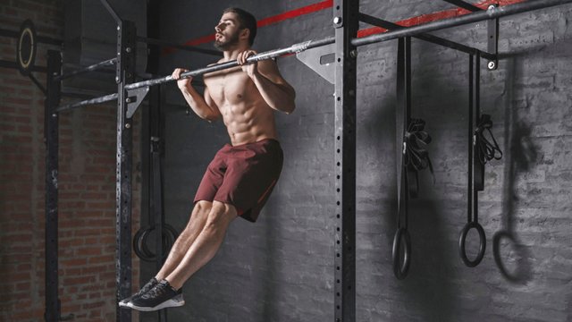 Muscular-Fit-Man-Working-Out-Without-A-Shirt-Doing-Plyometric-Pull-Ups.jpg